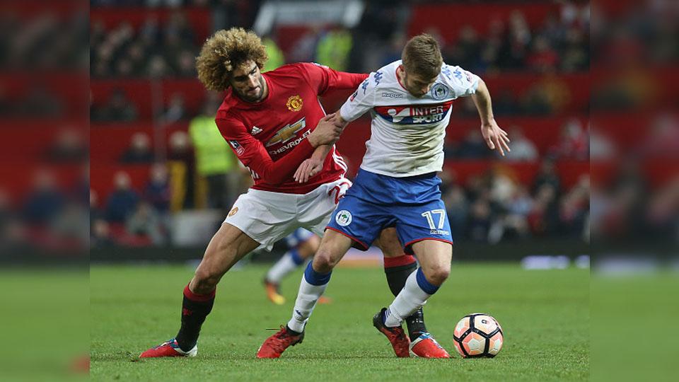 Marouane Fellaini berusaha menjaga pemain Wigan Athletic saat pertandingan babak keempat Piala FA. - INDOSPORT