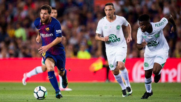 Pemain Chapecoense terlihat kesulitan menghentikan laju Lionel Messi. - INDOSPORT