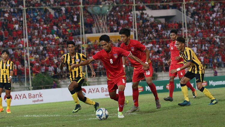 Pemain Myanmar saat mengontrol bola melawan Malaysia. - INDOSPORT