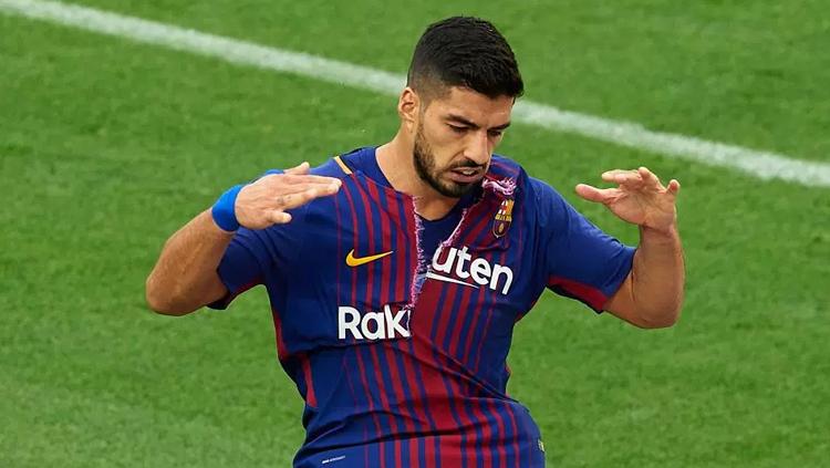Luis Suarez dengan sengaja merobek jersey miliknya sambil jalan menuju keluar lapangan. - INDOSPORT
