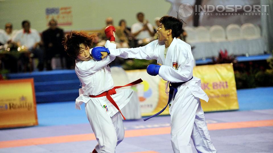 Tiara Pujakusuma (sabuk biru) mendaratkan pukulan telak kearah Kobayashi Miki (sabuk merah) pada pertandingan WKF Karate Premier League di Istora Senayan, Jakarta, Sabtu (21/06/14). - INDOSPORT