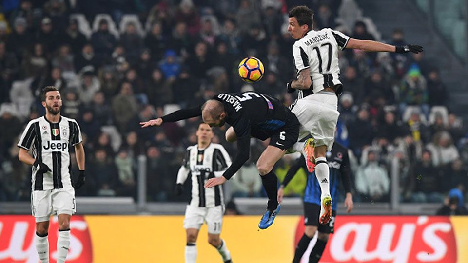 Mario Mandzukic berduel dengan bek Atalanta, Andrea Masiello. Copyright: Internet