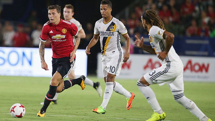 Victor Lindelof (kiri) saat menggiring bola melewati pemain LA Galaxy. Copyright: © INDOSPORT