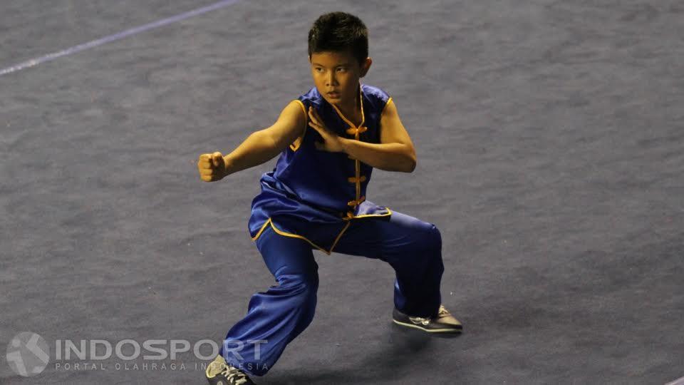 Aksi atlet wushu dari Wushu HTT Pusat Padang, Ibrahim Maulana di kelas Chang Quan Junior C pada Kejurnas Wushu Junior 2015 di Tennis Indoor Senayan, Senin (21/12/15).