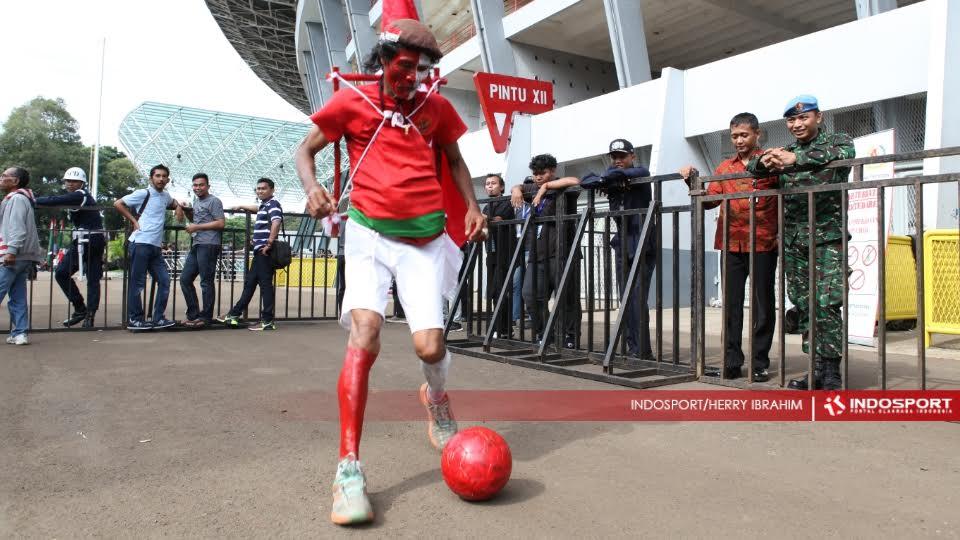 M Kurniawan, mantan atlet maraton Indonesia, dengan atribut timnas Indonesia meramaikan final Piala Jenderal Sudirman antara Semen Padang vs Mitra Kukar di GBK.