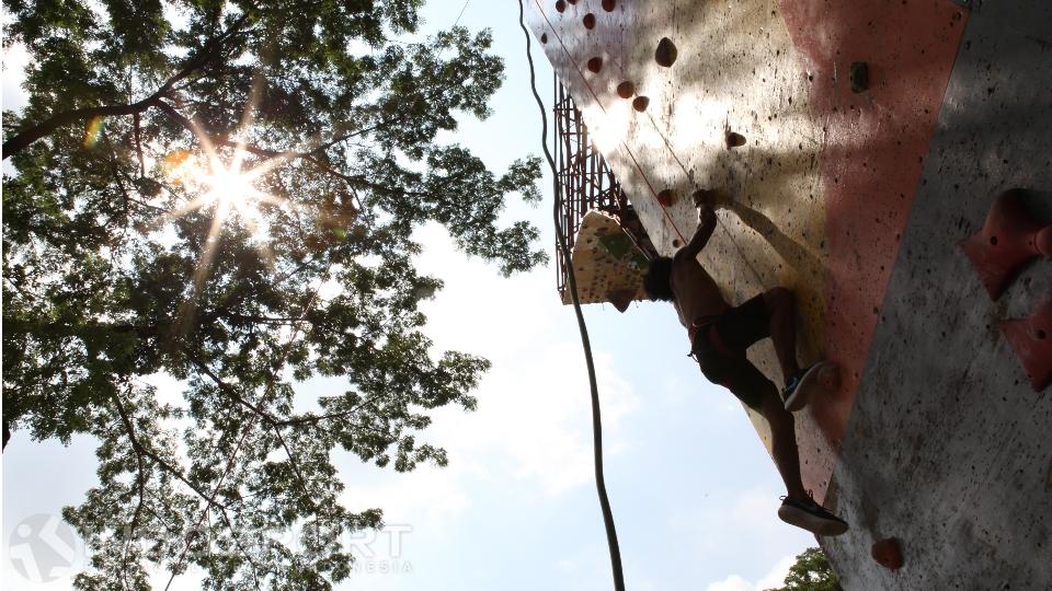 Seorang pemanjat tebing sedang berlatih di fasilitas climbing wall GOR Soemantri Brojonegoro.