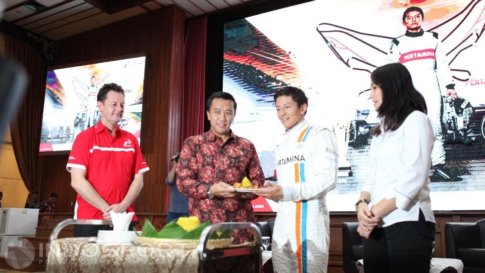 Rio Haryanto (tengah) melakukan pemotongan nasi tumpeng sebagai tanda syukur jelang keberangkatannya menjalani Race Formula 1 perdana di Melbourn.