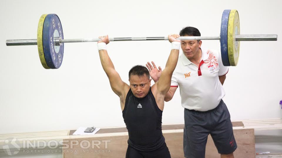 Pelatih angkat besi Indonesia Dirja Wiharja (belakang) sedang mengarahann atlet nya berlatih.