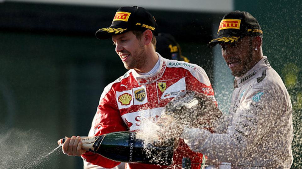 Sebastian Vettel merayakan keberhasilan finish podium bersama Lewis Hamilton. - INDOSPORT