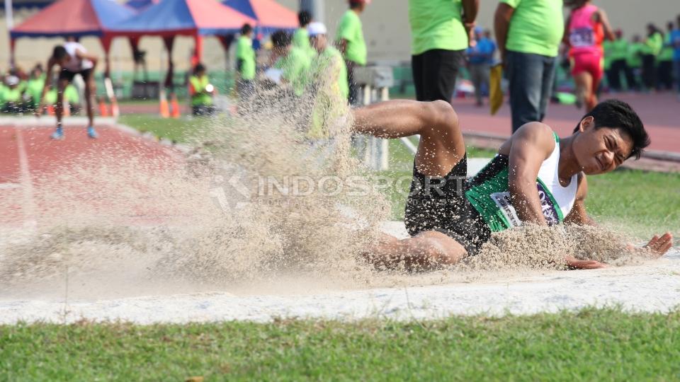 Atlet Jawa Timur, Rukun Adi melakukan lompat jauh di kelas Lompat Jauh Putra Junior.