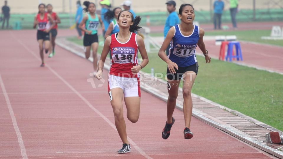 Atlet DKI Jakarta Novy Nur Nirwani (kiri) bersaing ketat oleh Atlet Maluku Kesia Hattu (kanan). Novy Nur berhasil menjuarai nomer 800 meter remaja putri.