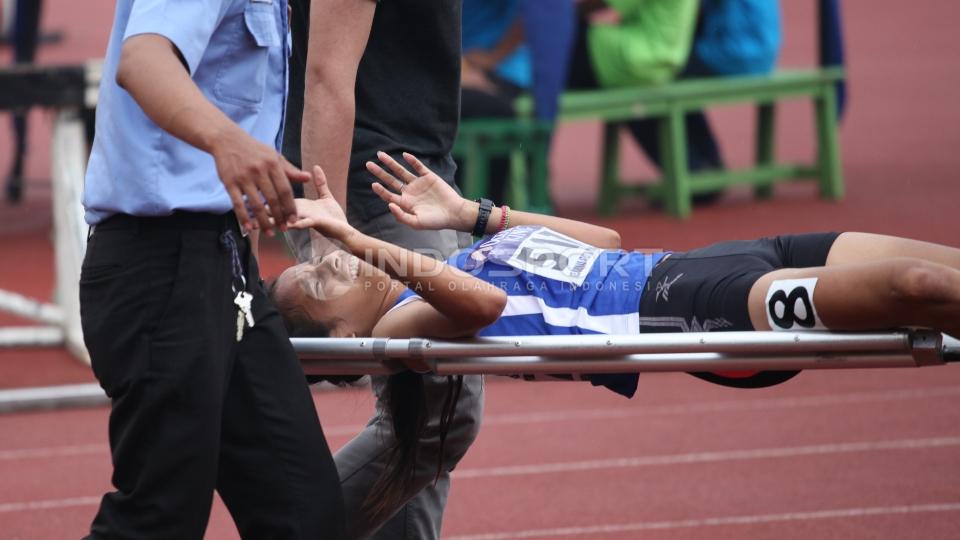 Seorang atlet mengalami cedera dan harus ditandu tim medis.