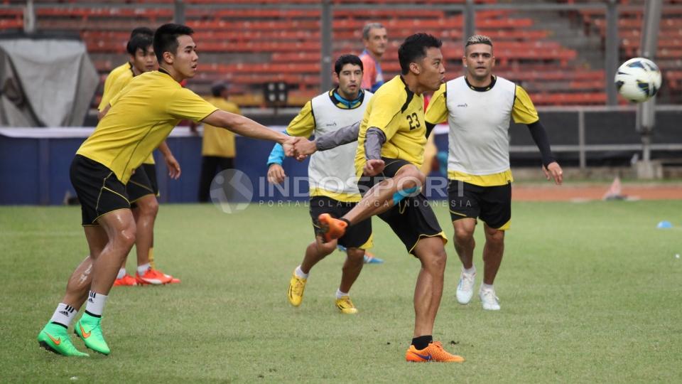 Aksi bek Arema Cronus Hamka Hamzah (tengah) saat menghalau bola.
