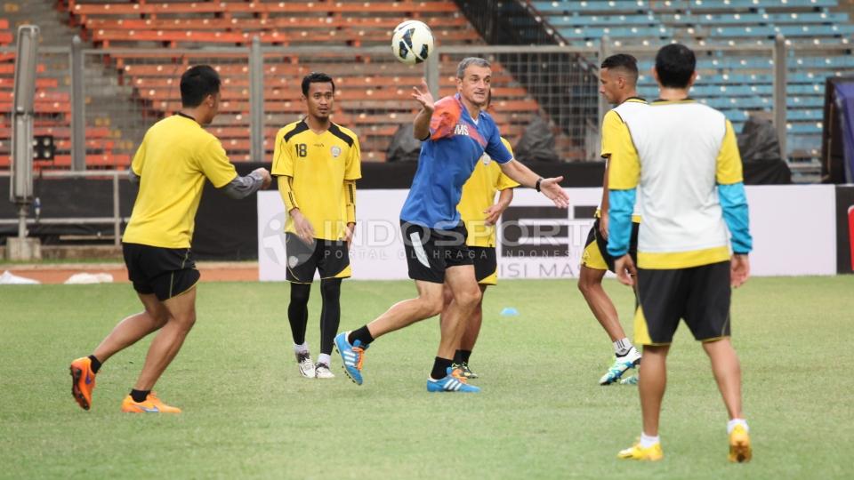 Pelatih Arema Cronus Milomir Seslija (tengah) saat mencontohkan gerakan kepada para pemainnya.