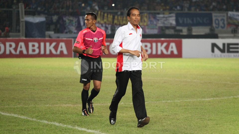 Presiden Indonesia, Jokowi berlari usai melakukan tendangan pembuka. Copyright: Herry Ibrahim/Indosport