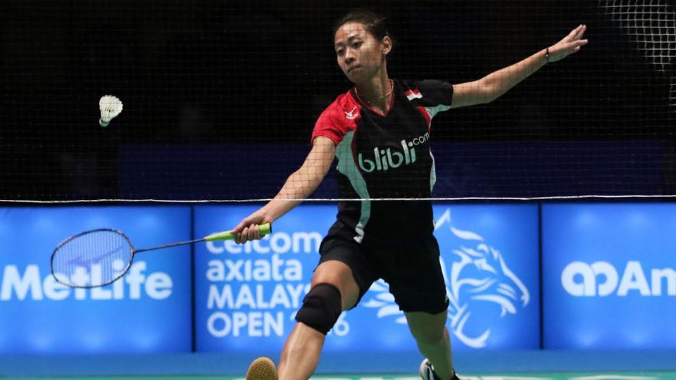 Maria Febe Kusumastuti berusaha smash shuttlecock dari jarak lumayan jauh.