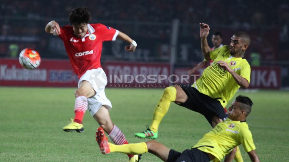 Tendangan Pemain Persija, Hong Soon Hok (kiri) dihadang dua pemain Semen Padang. - INDOSPORT