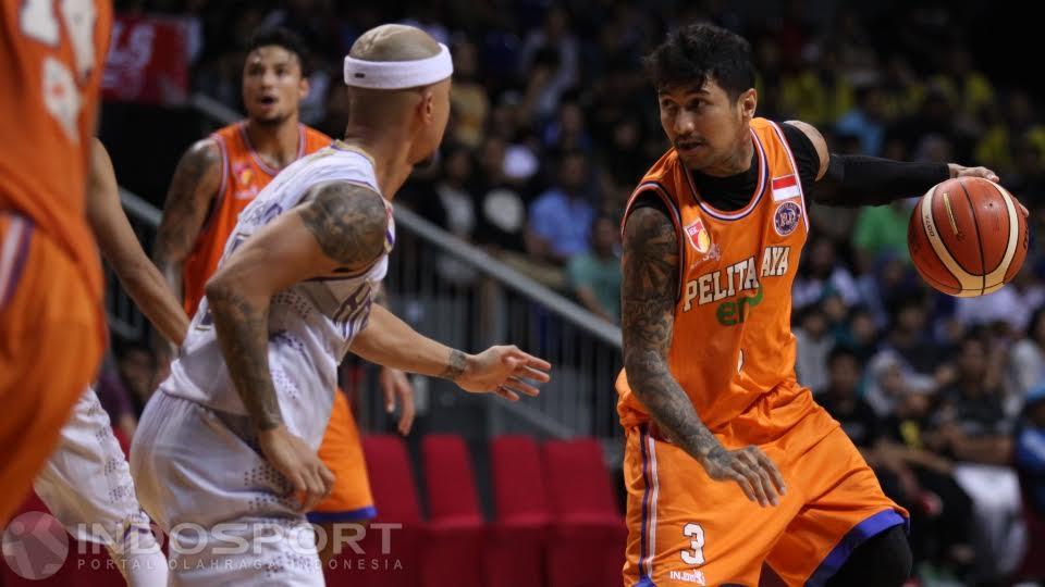 Mantan kapten Pelita Jaya Kelly Purwanto (kanan) selalu dijaga ketat pemain CLS Knights Mari Wuysang (tengah). - INDOSPORT