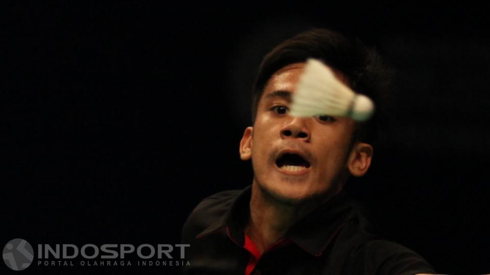 Tunggal putra Indonesia, Firman Abdul Kholik saat mengembalikan shuttlecock ke arah tunggal putra Singapura Zi Liang Derek Wong.