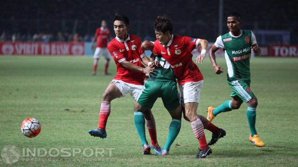 Seorang pemain PS TNI berusaha melewati dua pemain Persija Jakarta,
