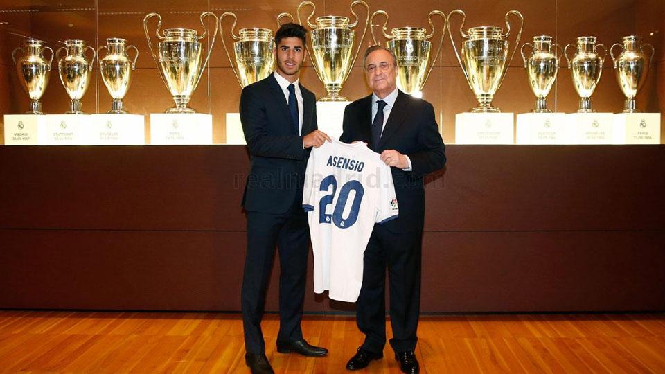 Marco Asensio dan Florentino Perez, dengan background koleksi trofi Liga Champions. Copyright: INTERNET