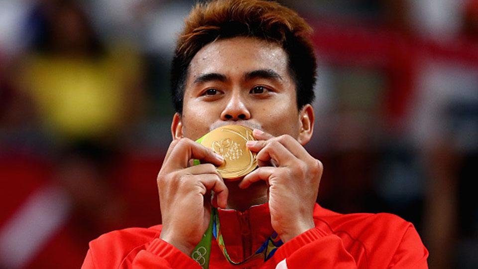 Tontowi Ahmad mencium medali emas. - INDOSPORT