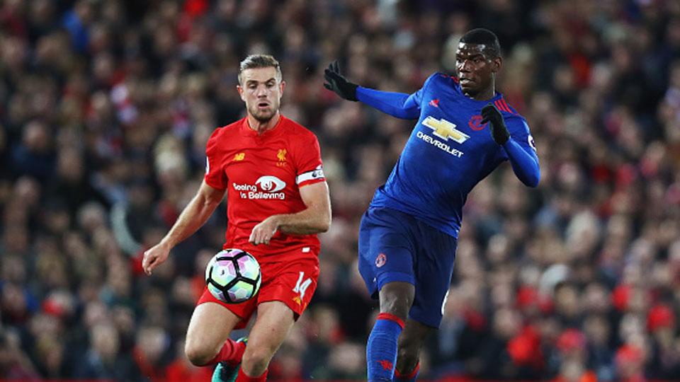 Paul Pogba berduel dengan gelandang Liverpool, Jordan Henderson di Stadion Anfield. - INDOSPORT