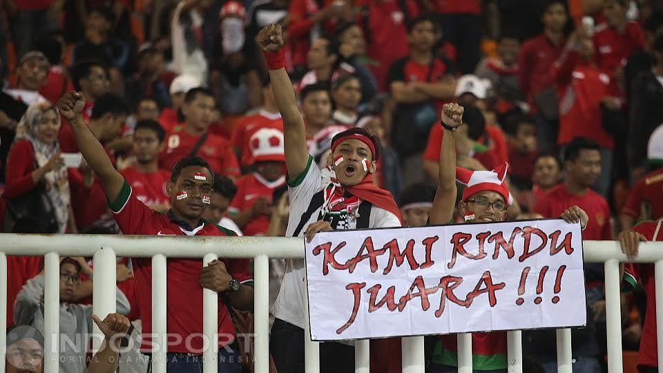 Suporter Indonesia terlihat semangat menyaksikan pertandingan Indonesai vs Thailand dengan membawa poster bertulisan, Kami Rindu Juara di Stadion Pakansari, Rabu (14/12/16).