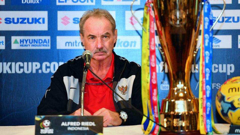 Pelatih Timnas Indonesia, Alfred Riedl menatap trofi Piala AFF Suzuki CUp 2016. Copyright: affsuzukicup