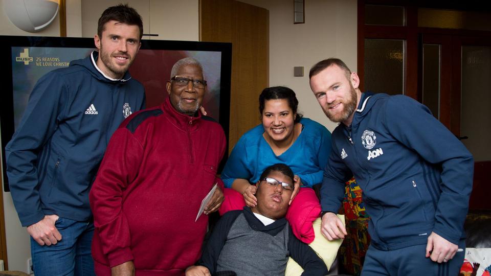 Kapten Manchester United, Wayne Rooney (kanan) bersama Michael Carrick (kiri) berfoto bersama keluarga pasien.