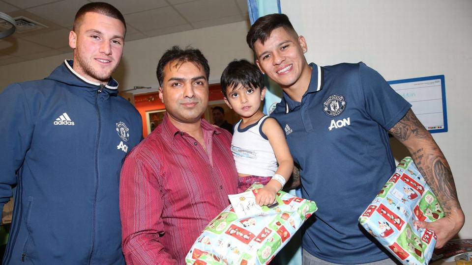 Sam Johnstone dan Marcos Rojo (kanan) memberikan kado Natal untuk seorang anak yang menjadi pasien Rumah Sakit Hospice of St Francis.