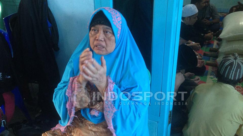 Ibunda Alm. Achmad Kurniawan, Hj. Maryani, mengangkat kedua tangannya mendoakan anaknnya.
