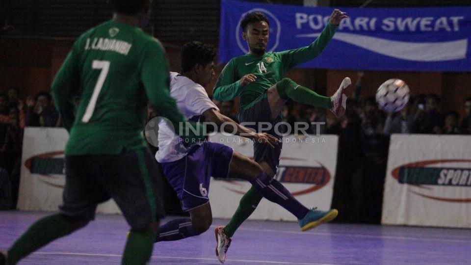 Pemain Timnas Futsal Indonesia, Randy Prasetya dihadang pemain Pelindo.