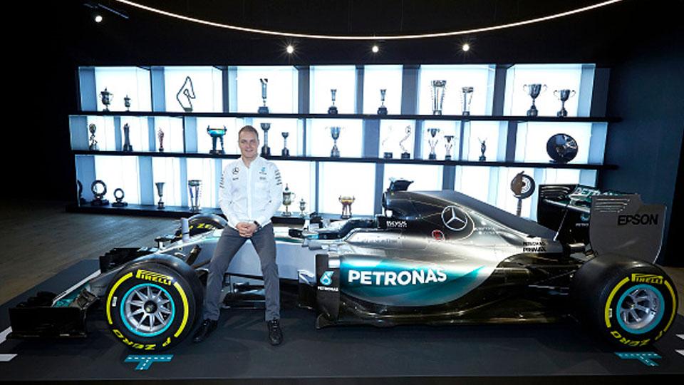 Pembalap anyar Mercedes, Valtteri Bottas pose di atas mobil saat diperkenalkan kepada awak media.