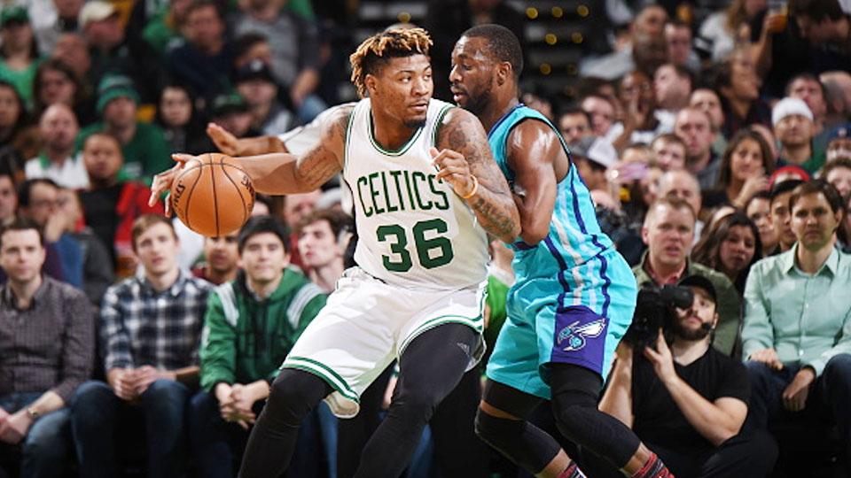 Marcus Smart (no 36) berusaha melewati pemain Charlotte Hornets.