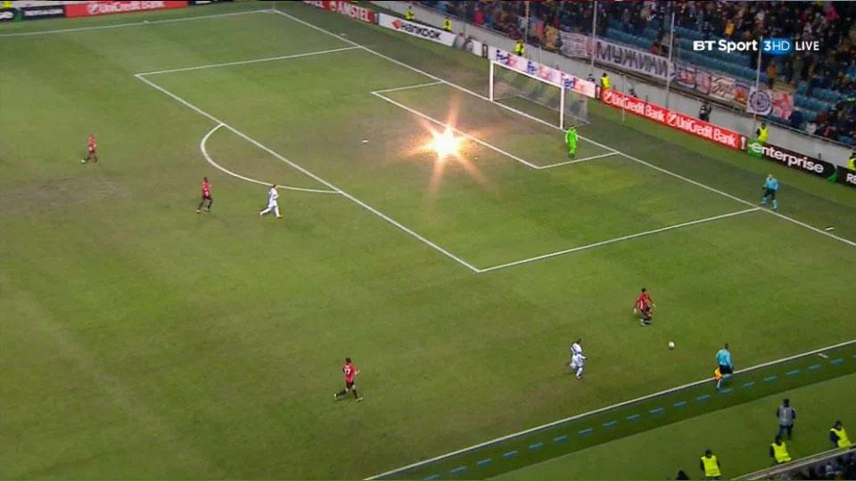 Sebuah petasan yang dilemparkan suporter ke arah gawang Sergio Romero saat Man United melawan Zorya Luhansk. - INDOSPORT