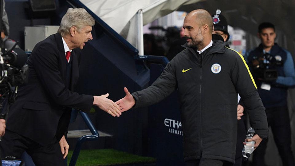 Pelatih Arsenal, Arsene Wenger (kiri) berjabat dengan pelatih Man City, Pep guardiola. Copyright: Michael Regan/Getty Images