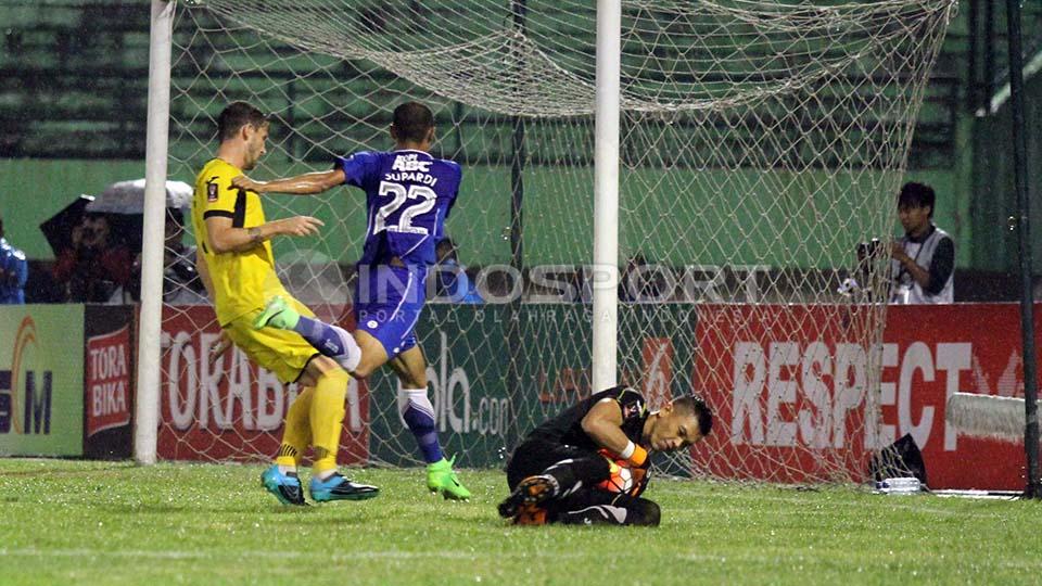 Aksi kiper Mitra Kukar, Gerri Mandagi antisipasi tendangan keras pemain Persib Bandung, Supardi.