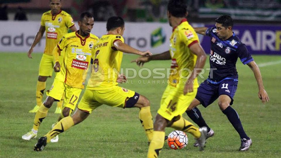 Esteban Gabriel Vizcarra (Arema FC) berusaha melewatkan beberpapa pemain Sriwijaya FC yang menghalaunya.