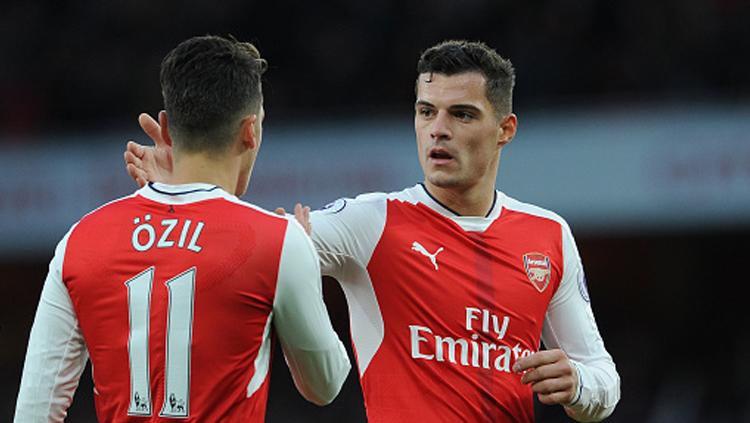 Granit Xhaka berikan selamat kepada Mesut Ozil setelah berhasil mencetak gol ke gawang AFC Bournemouth bulan November 2016 silam. - INDOSPORT