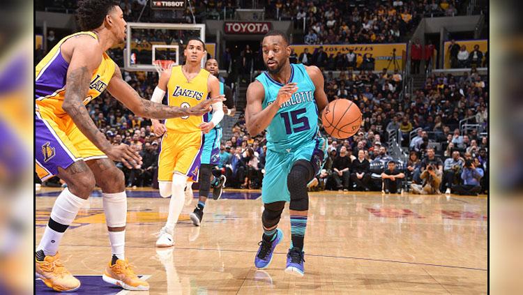 Kemba Walker berusaha melewati penjagaan pemain Lakers.
