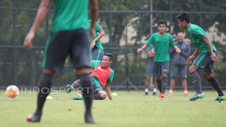 Evan Dimas (bawah) melakukan sliding tackel. Copyright: HERRY IBRAHIM/INDOSPORT