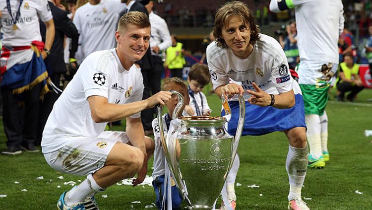 Toni Kroos (kiri) dan Luka Modric pose bersama trofi Liga Champions. Copyright: Chris Brunskill Ltd/Getty Images