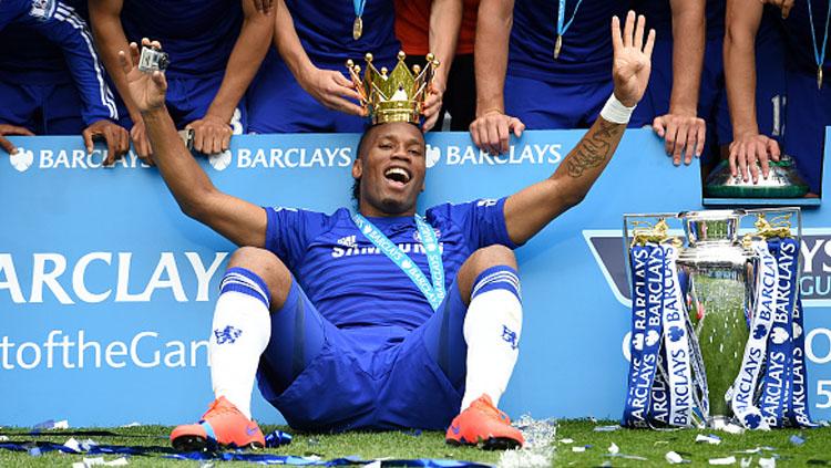 Didier Drogba saat masih berseragam Chelsea, berpose bersama trofi Liga Inggris.