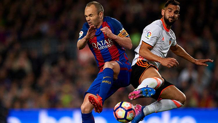 Andres Iniesta (kiri) berusaha merebut bola dari Martin Montoya. Copyright: Manuel Queimadelos Alonso/Getty Images