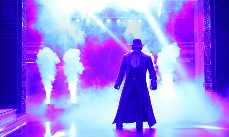 The Undertaker saat masuk ke ring. - INDOSPORT
