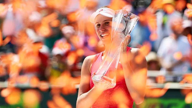 Johanna Konta tersenyum saat ia memegang piala setelah mengalahkan Caroline Wozniacki. - INDOSPORT
