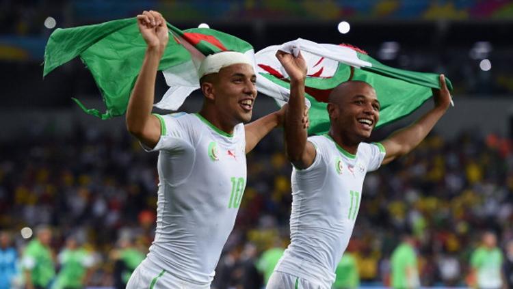 Sofiane Feghouli dan Yacine Brahimi meryakan keberhasilan Aljazair menahan imbang Rusia di Piala Dunia 2014 silam. - INDOSPORT
