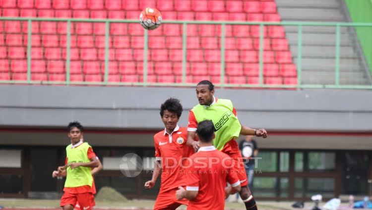 Salah satu pemain Persija Jakarta akan menahan bola dari rekan setimnya.
