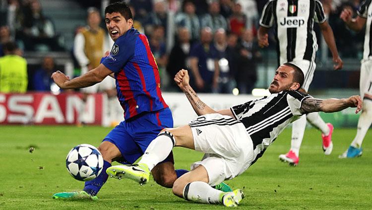 Giorgio Chiellini tampak menjegal Luis Suarez pada pertandingan Liga Champions leg pertama. - INDOSPORT